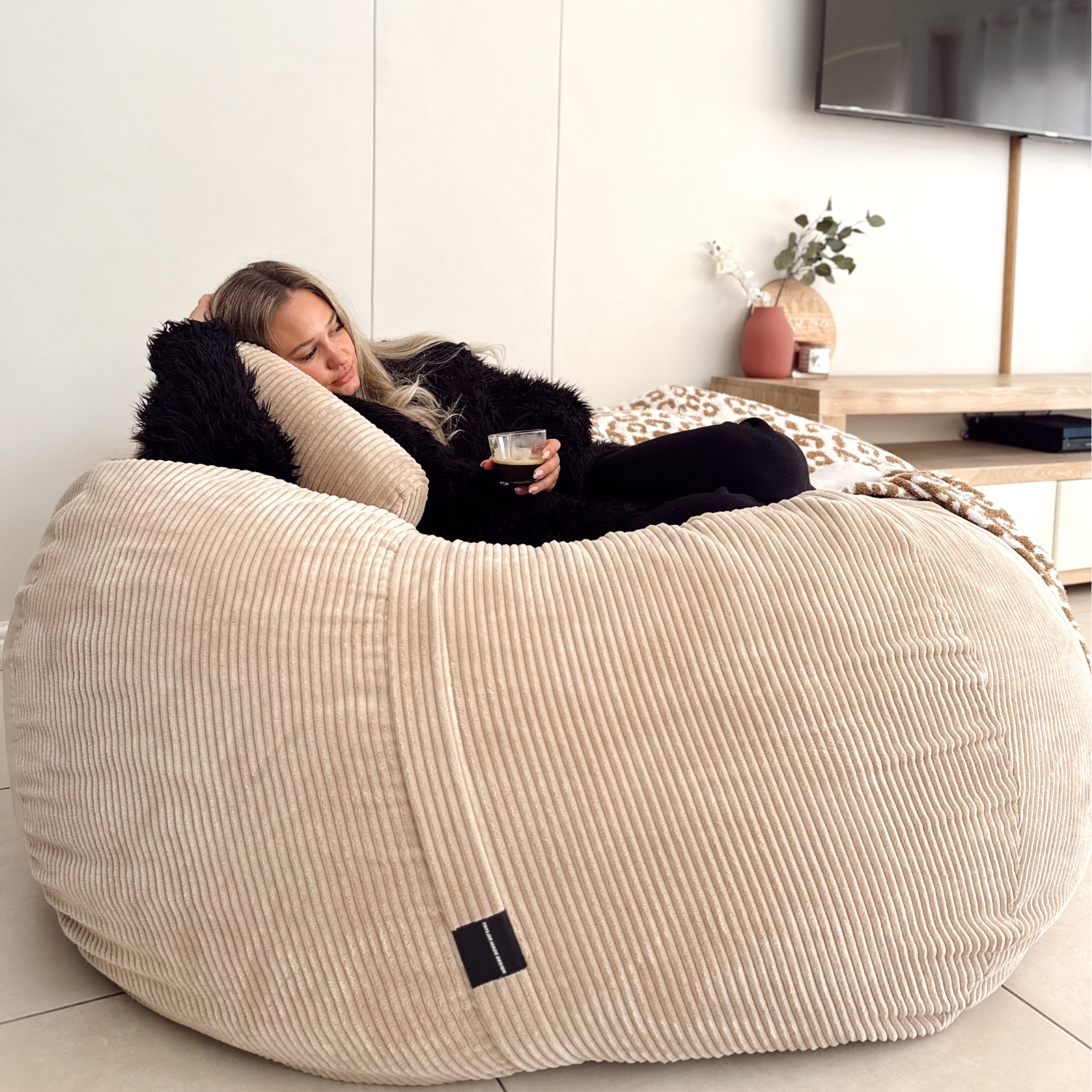 A beautiful lady on a premium XL camel bean bag
