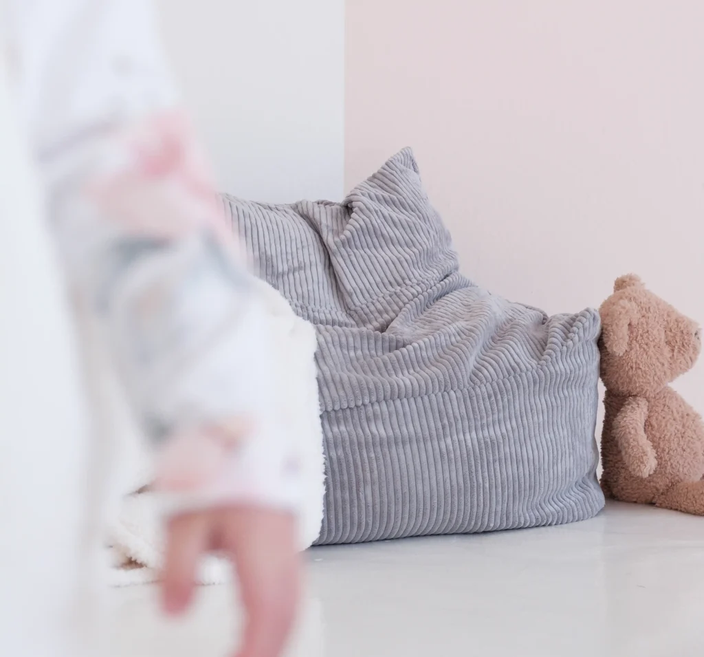 a young girl standing infront of a cloud sofa